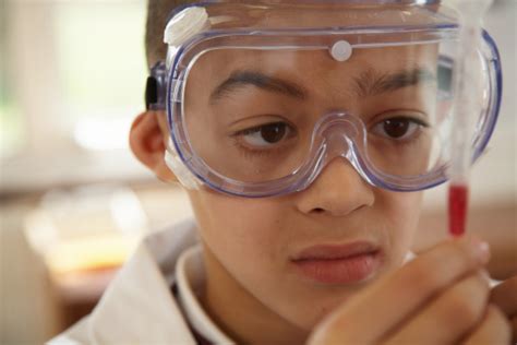 istock child gholding pipette|Schoolboy wearing protective goggles holding up pipette .